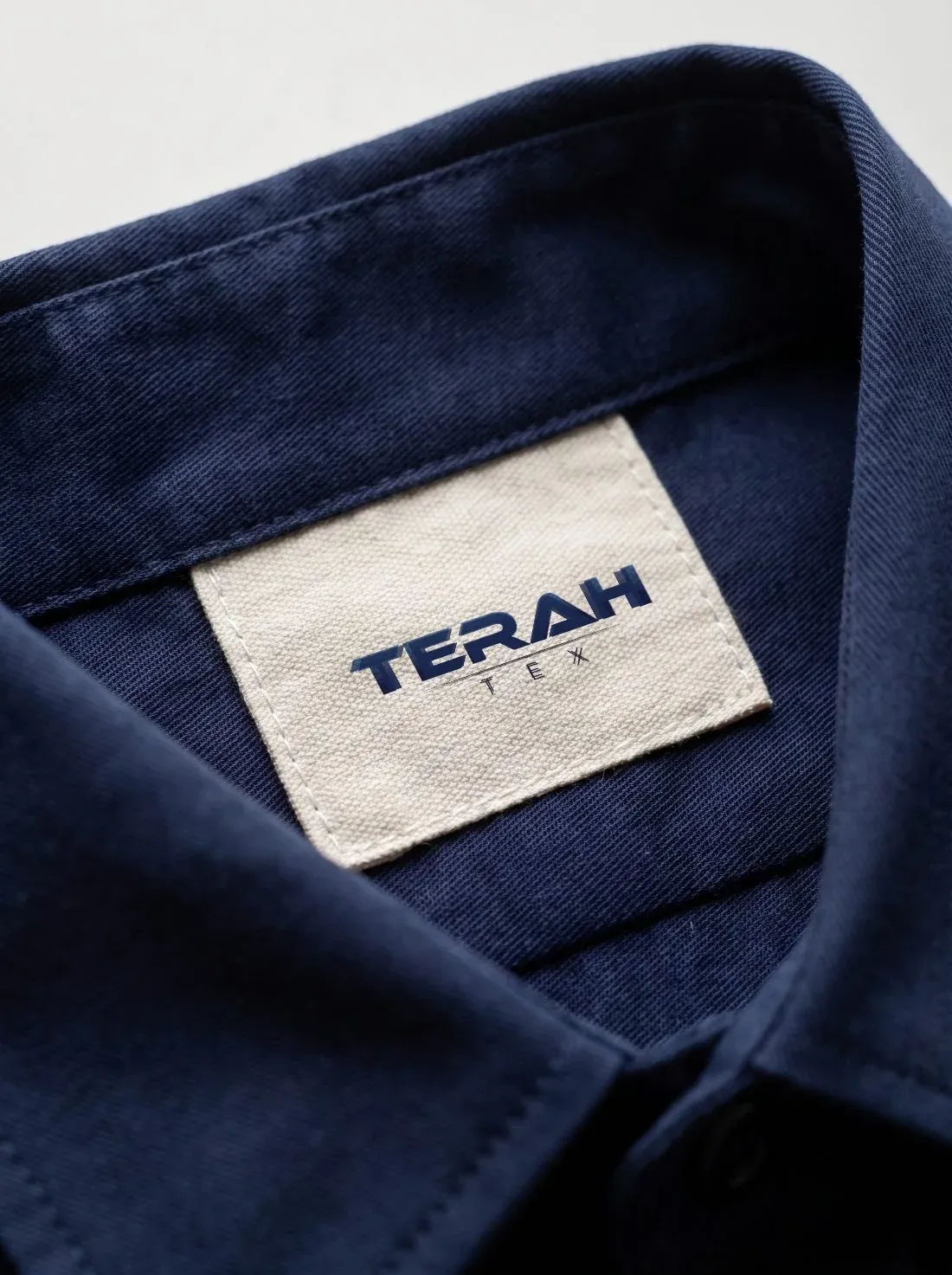 Custom woven neck label stitched inside a uniform shirt collar — private label uniform manufacturing in Chennai